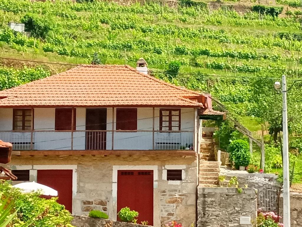 una casa con puertas rojas frente a una montaña en D. Maria São Pedro de Balsemão, en Lamego