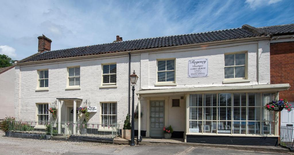 un edificio blanco con un cartel. en Regency Guest House, en Neatishead