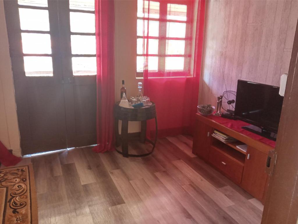 a living room with red curtains and a television at D. Maria São Pedro de Balsemão in Lamego