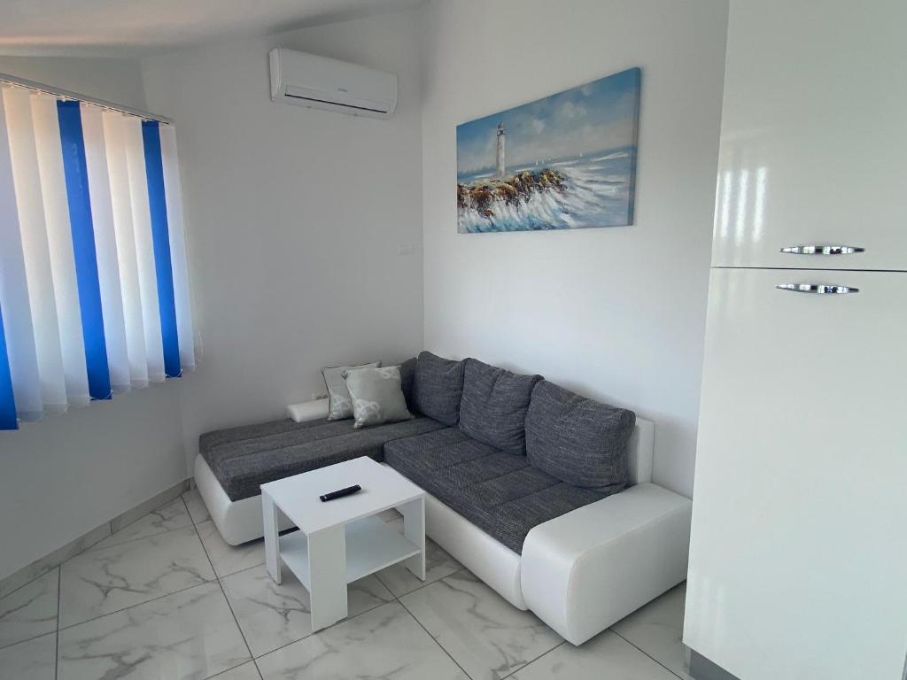 a white living room with a couch and a table at Villa Mara in Pula