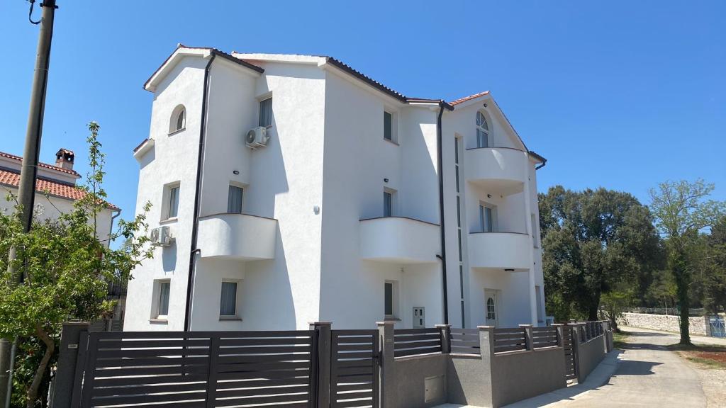 a white building with a fence in front of it at Villa Mara in Pula