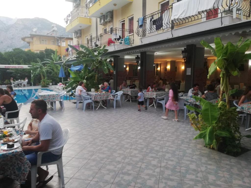 a group of people sitting at tables in a restaurant at Santana Hotel in Beldibi