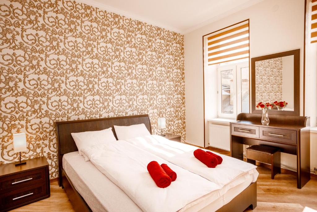 a bedroom with a bed with two red pillows on it at Apartments Rynok Square 12 in Lviv