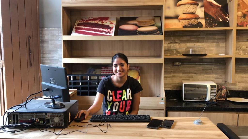 a woman sitting at a desk with a computer at Americo Hostel in São Luís