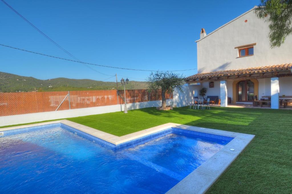 a swimming pool in a yard next to a house at Villa Can Roig by Hello Homes Sitges in Sant Pere de Ribes