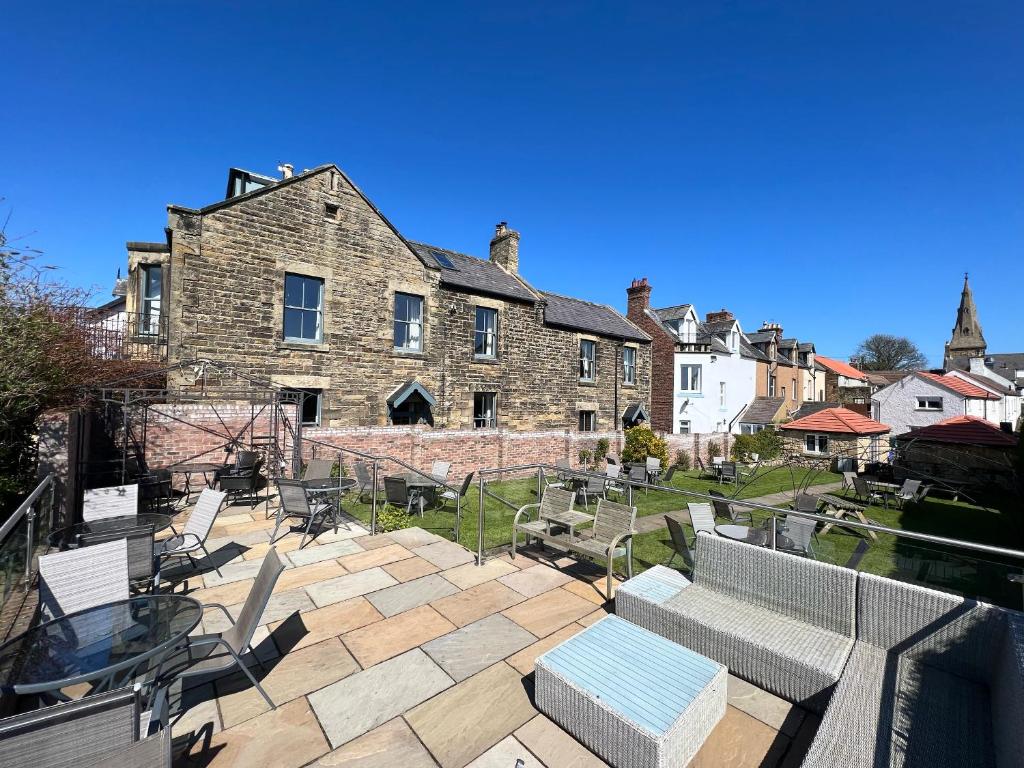 a patio with chairs and tables in front of a building at The Red Lion Inn Alnmouth in Alnmouth