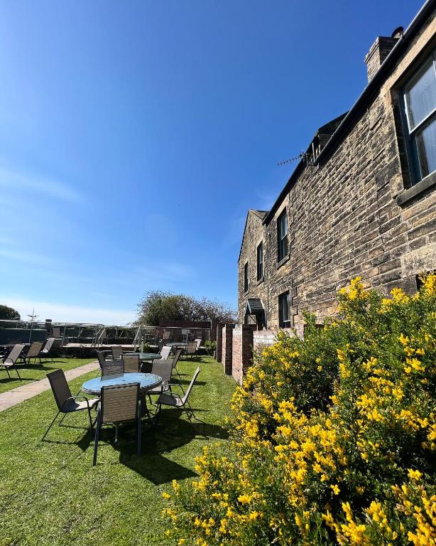 a patio with a table and chairs next to a building at The Red Lion Inn Alnmouth in Alnmouth