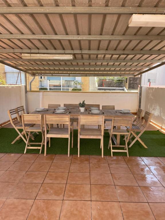 a dining table and chairs under a roof at UIM Mediterraneo Libertad 1 Wifi in Puerto de Sagunto
