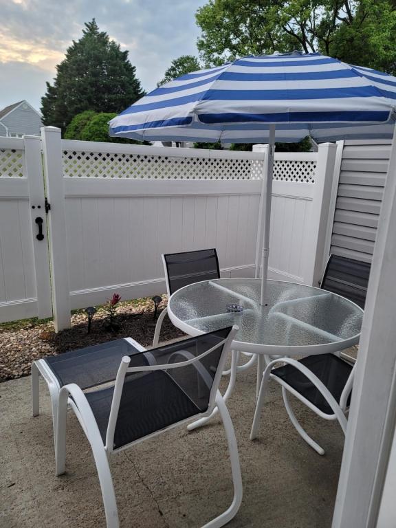 un tavolo con sedie e un ombrellone su un patio di Heart of Raleigh a Raleigh