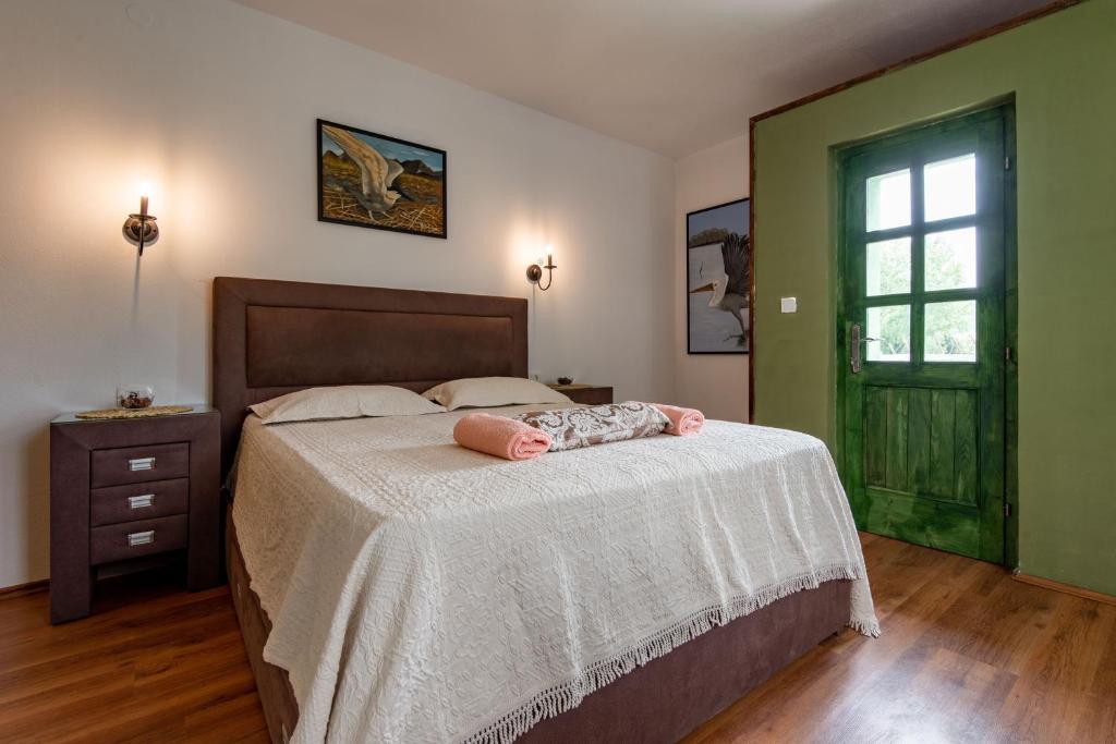 1 dormitorio con 1 cama con manta blanca y ventana en Apartments MIONA en Virpazar