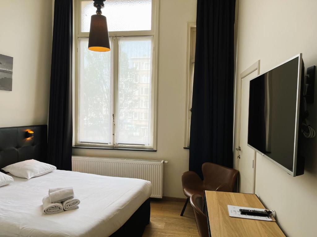 Rúm í herbergi á Hotel Le Parisien