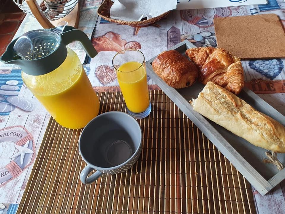 una mesa con una bandeja de pan y dos vasos de zumo de naranja en Oharas en Mansigné