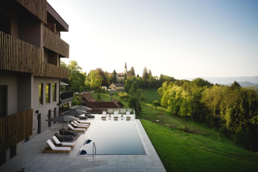 uma fila de cadeiras brancas ao lado de um edifício em Boutiquehotel DAS ZEITWERT em Deutschlandsberg