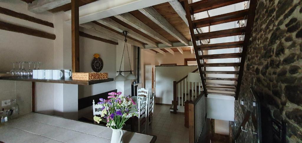 een keuken met een trap en bloemen in een vaas bij Casa Clara in Borredá