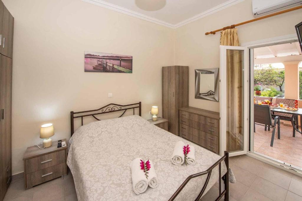 - une chambre dotée d'un lit avec deux chaussures blanches dans l'établissement Lollas Apartments Acharavi Corfu, à Acharavi