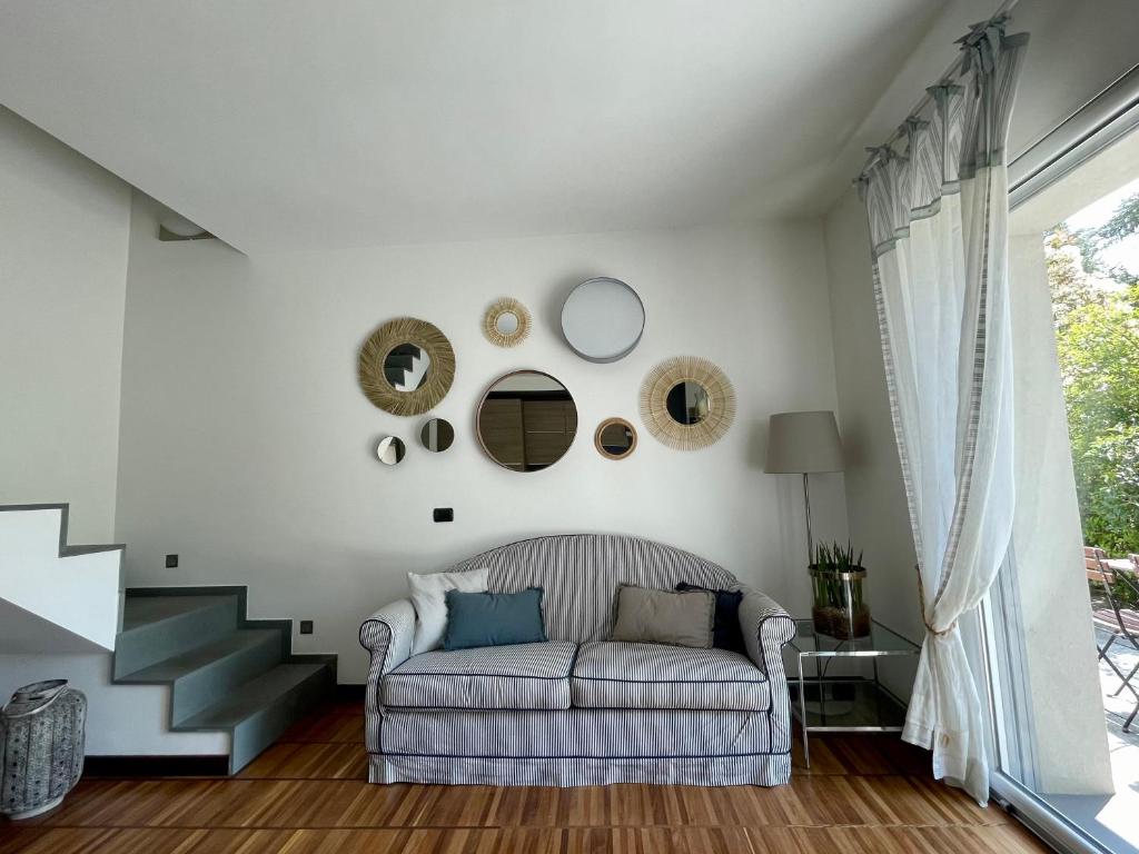 een woonkamer met een bank en een trap bij MY HUMBLE HOUSE -Appartamento in villa con vista lago in Oggiono