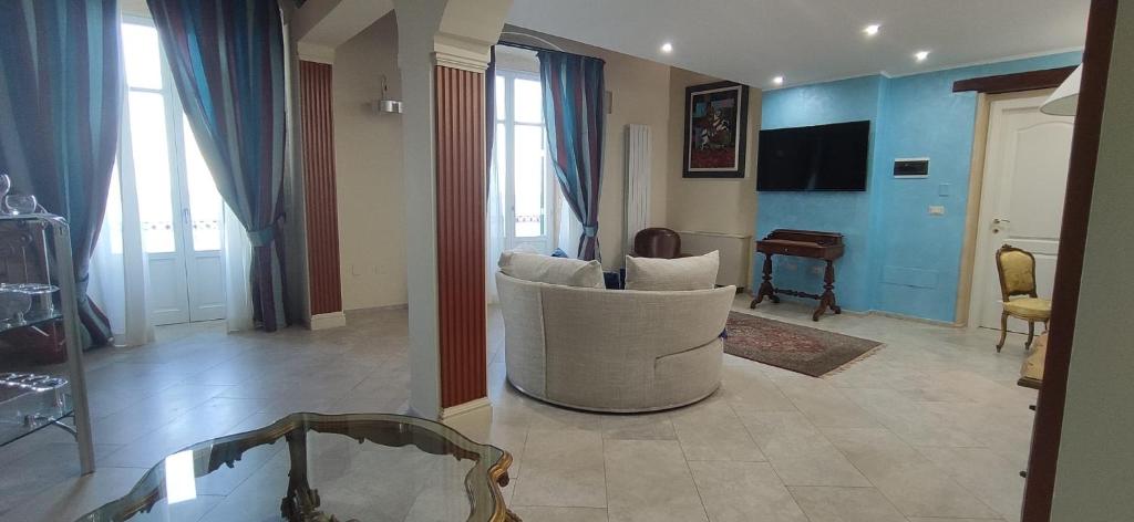 a living room with a white chair and a table at Hotel Ortigia Royal Suite in Syracuse