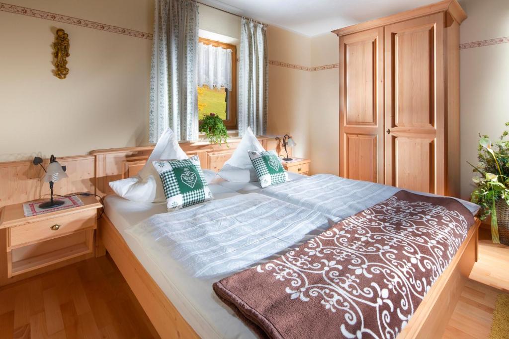 um quarto com uma cama grande e uma janela em Gästehaus Lärcheck Berchtesgaden FeWo Morgensonne em Berchtesgaden