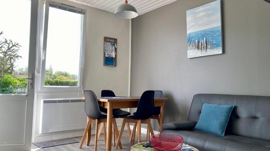 un salon avec une table, des chaises et un canapé dans l'établissement Les Figuiers N°2 - Repos et tranquillité, à La Michelière