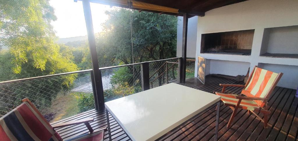 een balkon met een tafel en 2 stoelen en uitzicht bij Cabaña con Pileta Sobre Camino Del Cuadrado En La Montaña Con Vistas Increíbles - Cerca De Todo in Río Ceballos