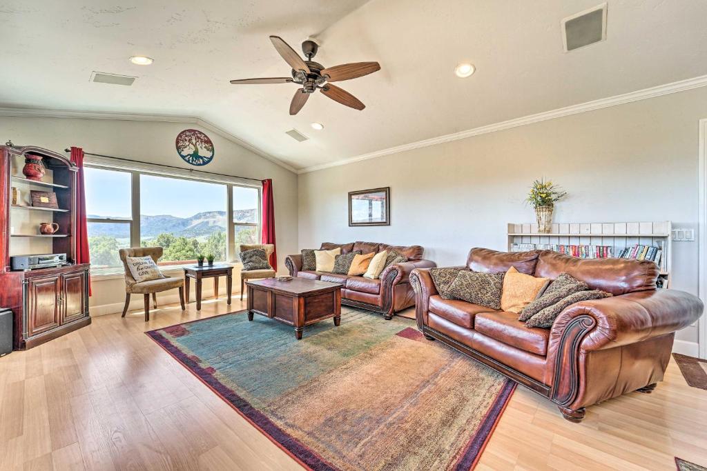 sala de estar con muebles de cuero y ventilador de techo en Scenic Mancos Hideaway Less Than 3 Mi to Mesa Verde!, en Mancos