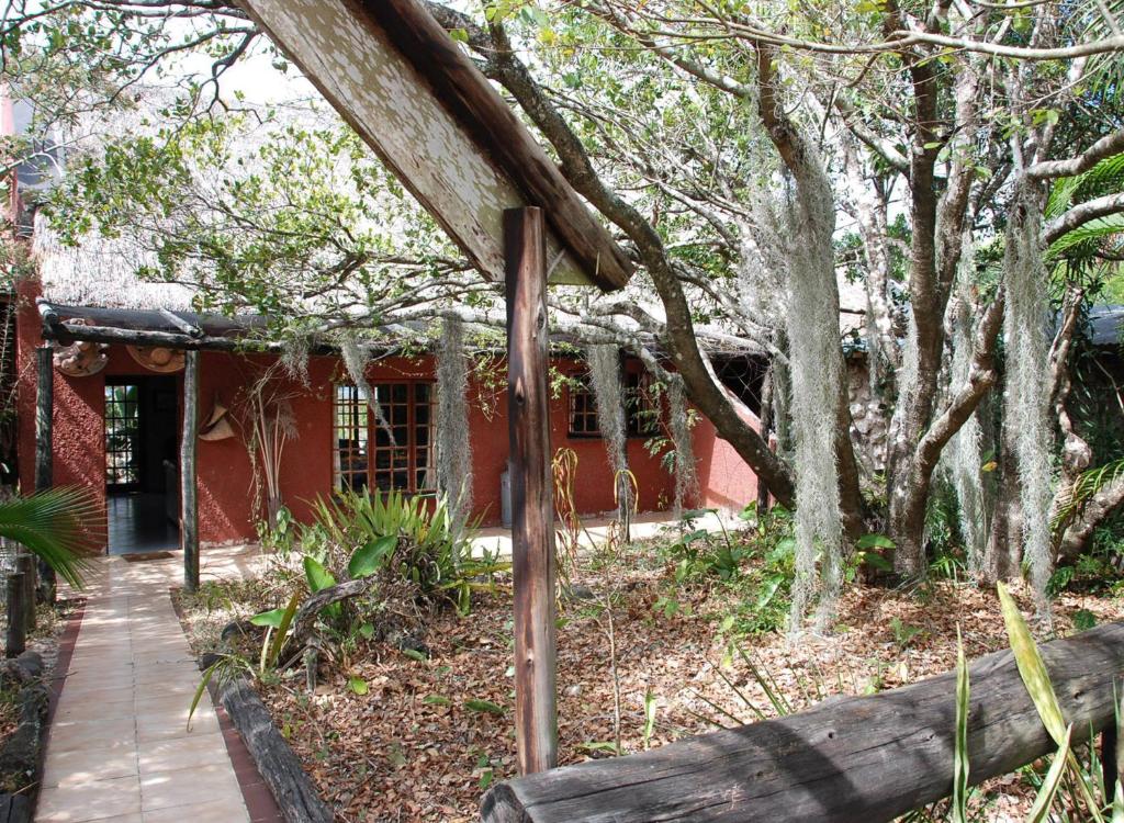 a red house with trees and a walkway at Kosi Moon Bed and Breakfast in Manguzi