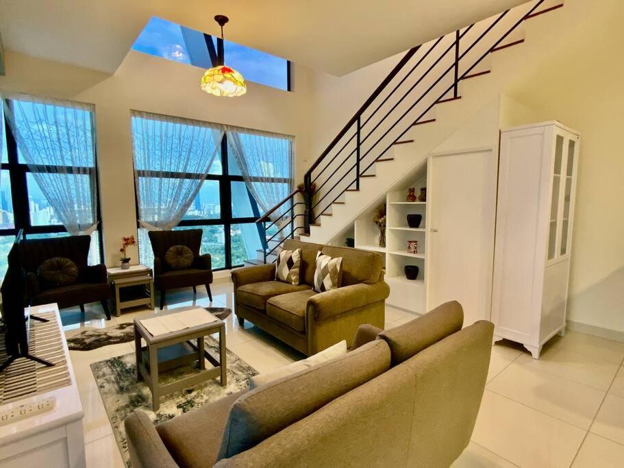 a living room with two couches and a staircase at Duplex Corner Unit Arte Mont Kiara 2BR in Kuala Lumpur