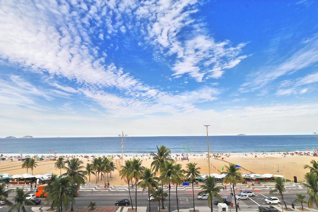 vistas a una playa con palmeras y al océano en Rio Spot Atlantica 2440, en Río de Janeiro