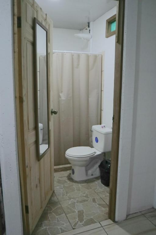 łazienka z toaletą i lustrem w obiekcie Amaya's Hostel w mieście Jaloba
