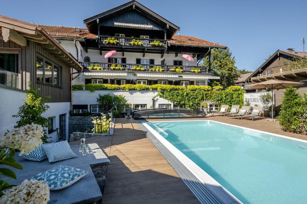 un hotel con piscina frente a un edificio en Boutique Hotel Relais Chalet Wilhelmy en Bad Wiessee