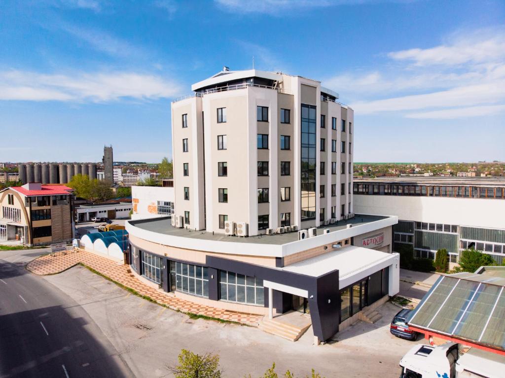 a large white building with a solar panel on it at Hotel Verticalplus in Haskovo