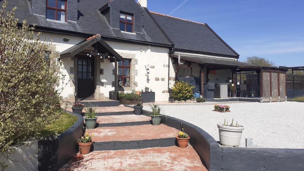 a house with a courtyard with potted plants at Locarn Lodge, Goas Rep in Locarn