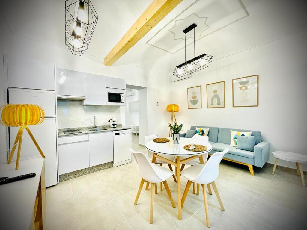 uma cozinha e uma sala de estar com mesa e cadeiras em Apartamentos Guaditania em Mérida
