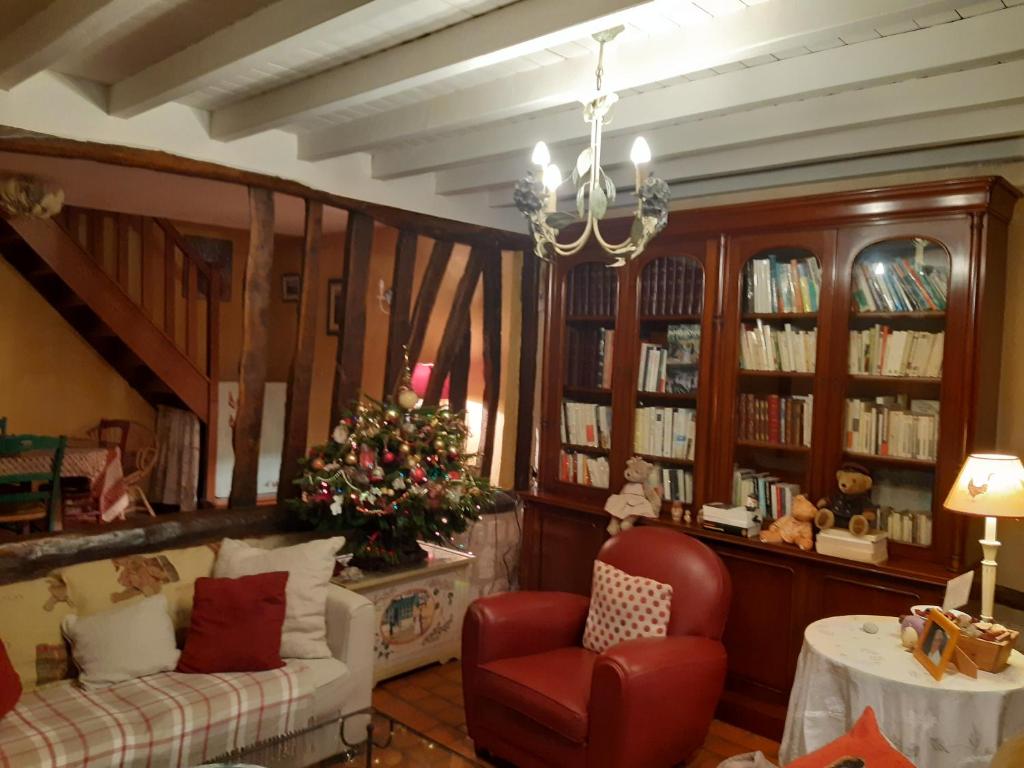 a living room with a christmas tree and a couch at les orchidees sauvages in Touffreville-la-Corbeline