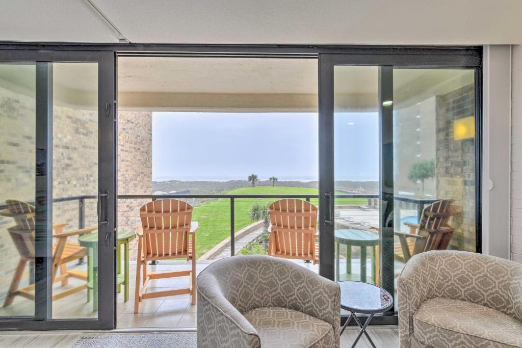 a living room with glass doors and rocking chairs at Condo Walk to Beach, 3 Miles to Port Aransas! in Port Aransas