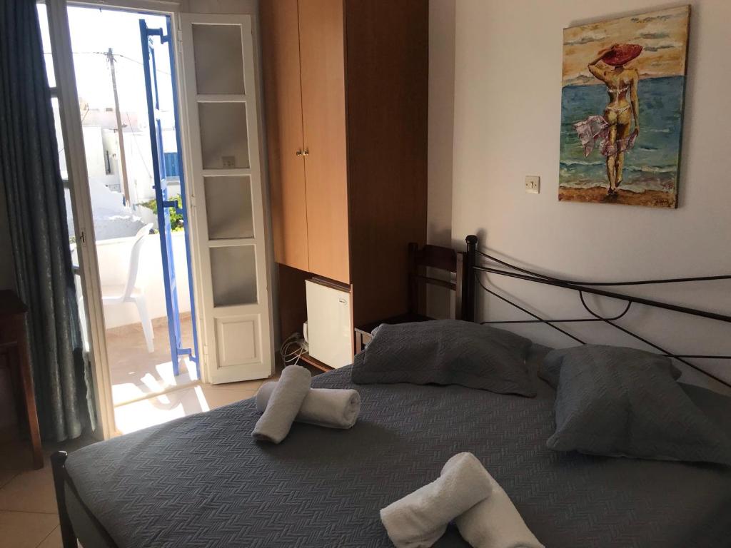 a bedroom with a bed with two towels on it at Aegeon Pension in Aegiali