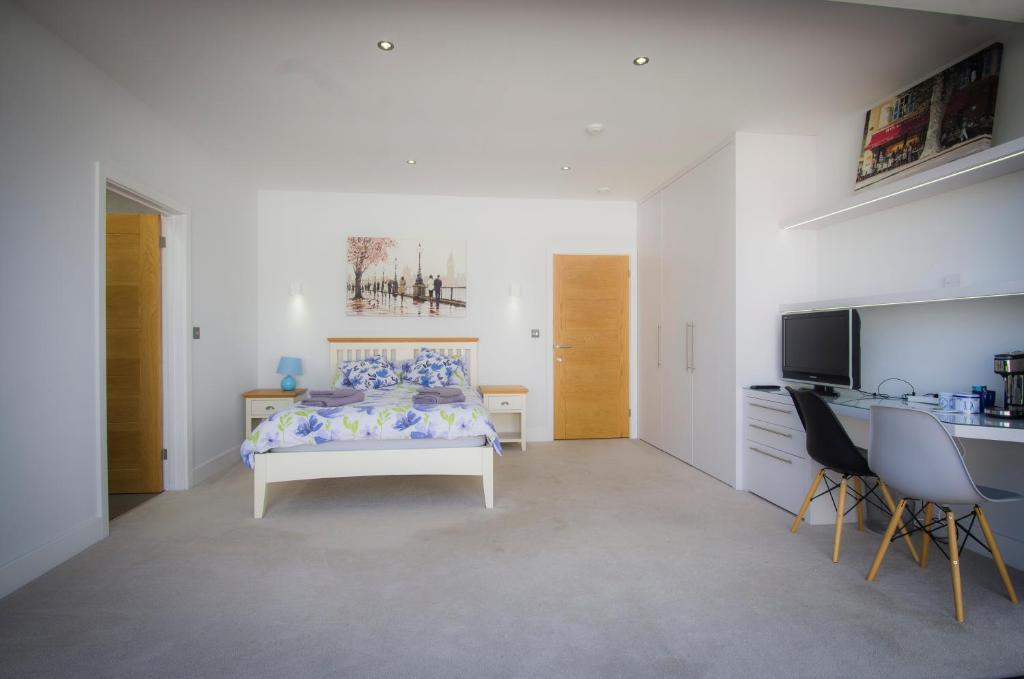 a bedroom with a bed and a desk and a television at Allen Ridge in Hythe