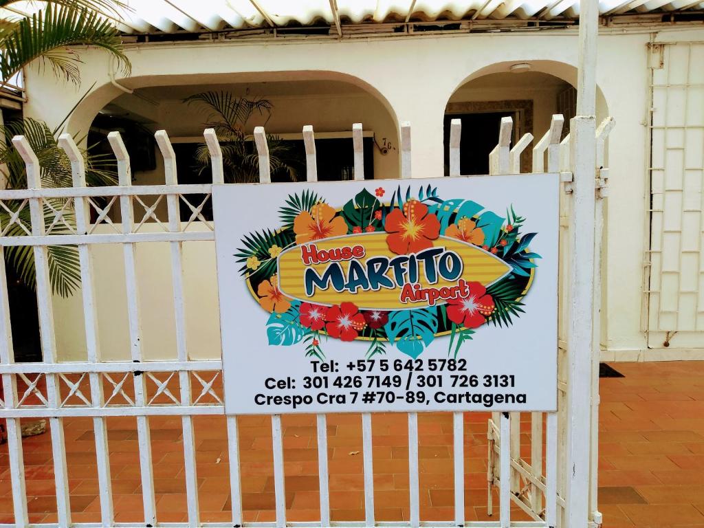 un cartello su un cancello di fronte a un edificio di House Marfito Airport a Cartagena de Indias