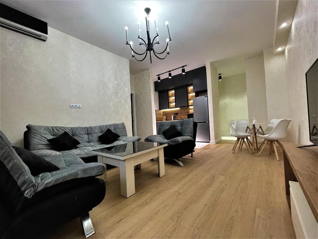uma sala de estar com sofás e uma sala de jantar em Apartment D. Digomi em Tbilisi