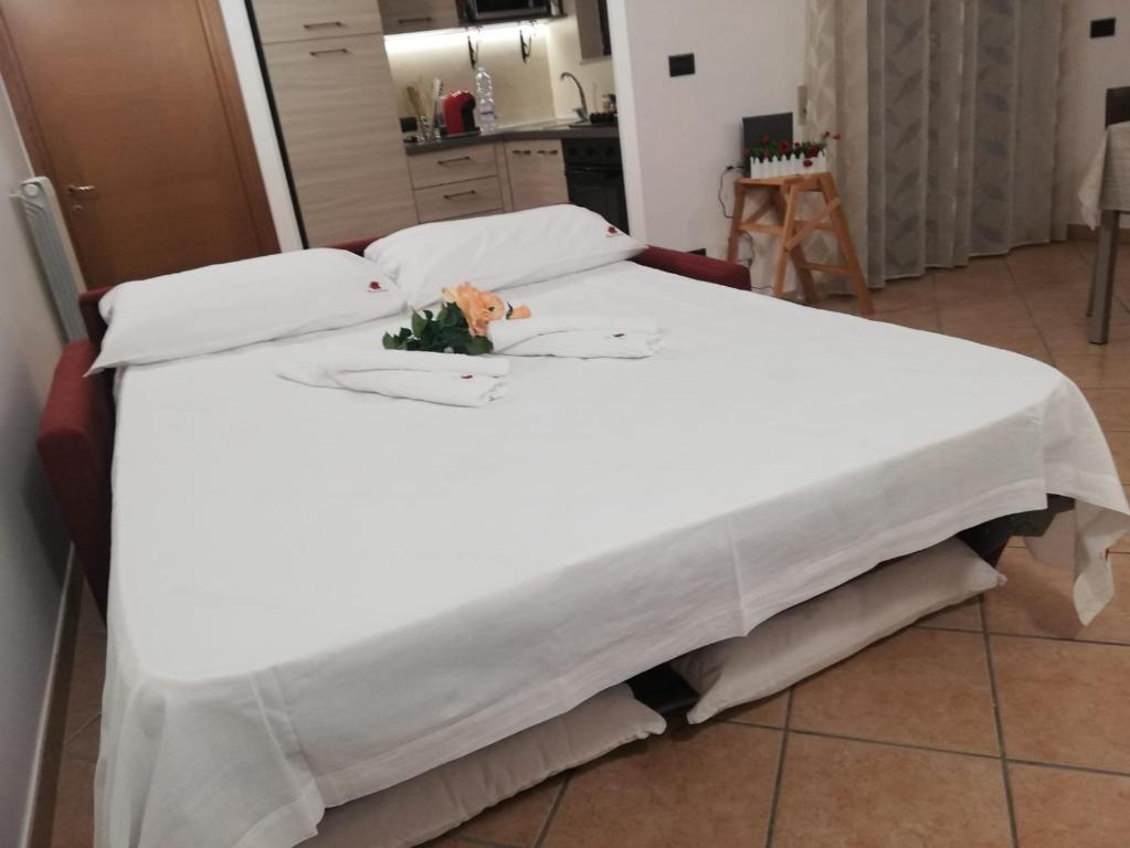 łóżko z białą narzutą i kwiatami w obiekcie Rosahouse w mieście Lecce