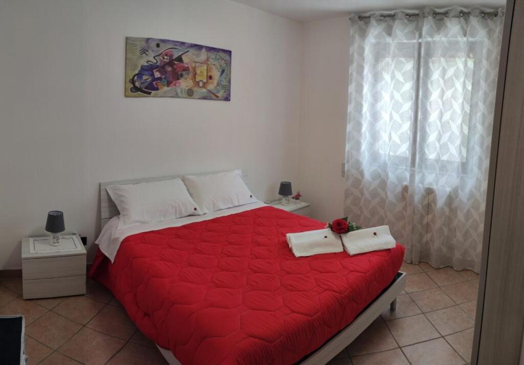 sypialnia z czerwonym łóżkiem i 2 ręcznikami w obiekcie Rosahouse w mieście Lecce