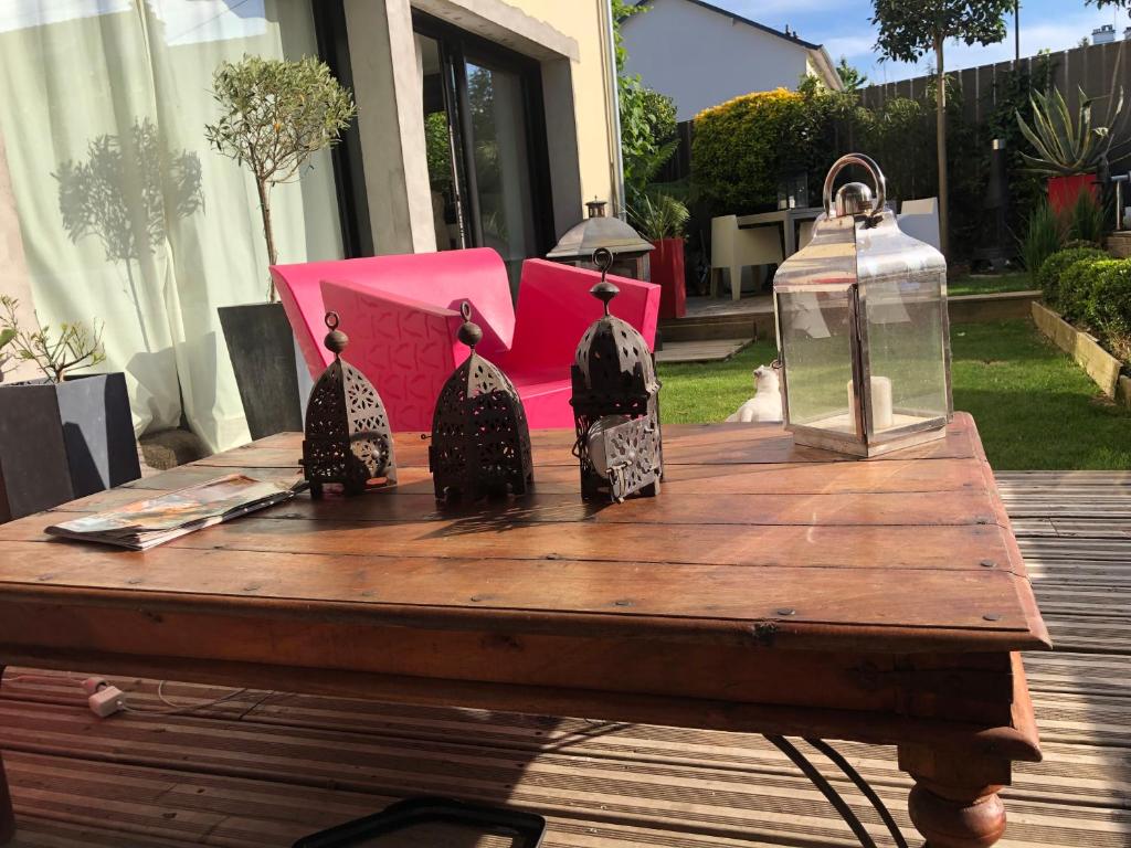 una mesa de madera con cuatro botellas de cristal encima en Chambre hôtes nichée sous les toits en Rennes