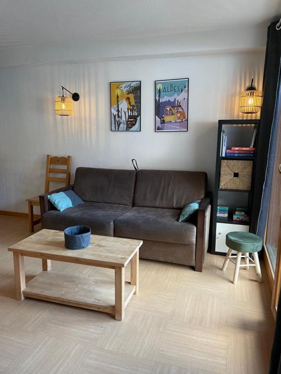 a living room with a couch and a coffee table at Front neige 1800, cosy 4-6p, parking couvert in Les Orres