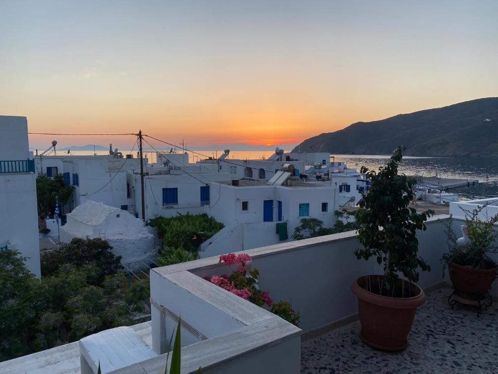 a view of a town at sunset from a house at Aegeon Pension in Aegiali