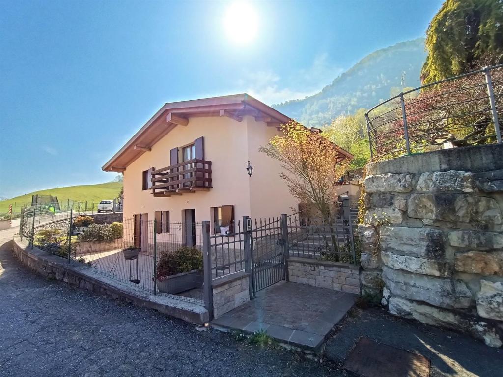 mały dom z ogrodzeniem i kamienną ścianą w obiekcie IseoLakeRental - Chalet Giulia w mieście Sovere