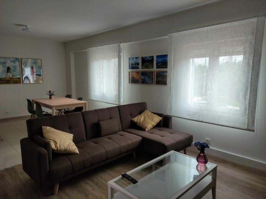 sala de estar con sofá marrón y mesa en Grupo Gontad Apartamento Ponteceso Pé do Río en Ponteceso