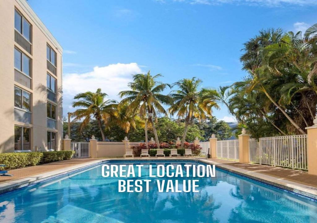 a sign that reads great location best value next to a swimming pool at La Quinta Inn & Suites by Wyndham Sunrise in Sunrise