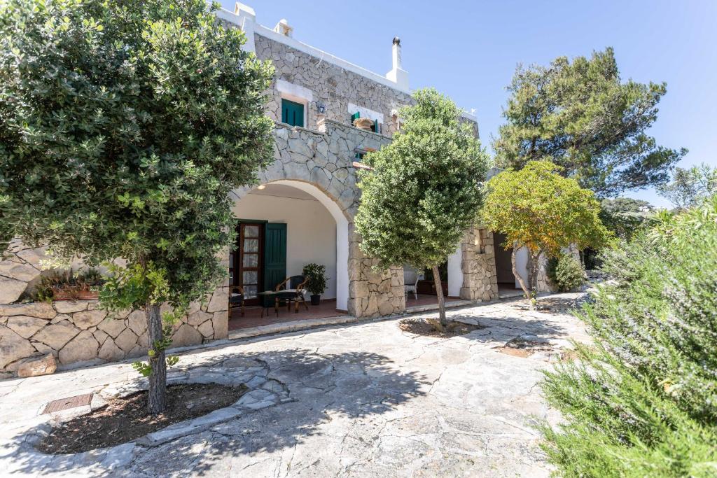 una vista esterna di una casa in pietra con alberi di Il Posto delle Fragole a Castro di Lecce
