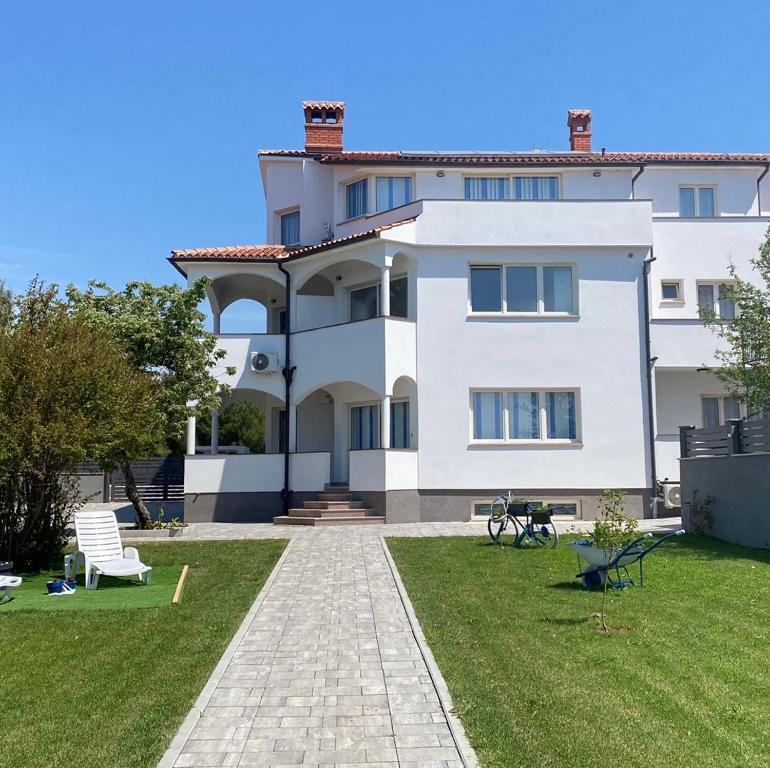 a large white house with a lawn in front of it at Villa Mara in Pula