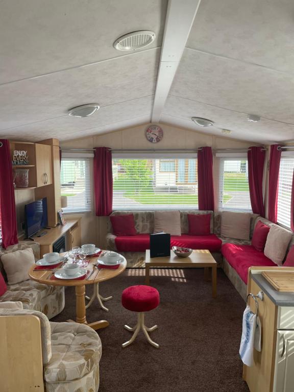 a living room with a couch and a table at Calypso Hot Tub Breaks Tattershall Lakes Pet Friendly in Tattershall